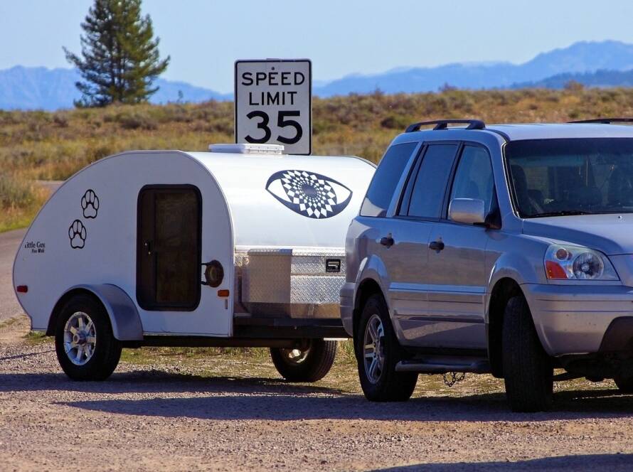 Teardrop trailer towed by a small SUV